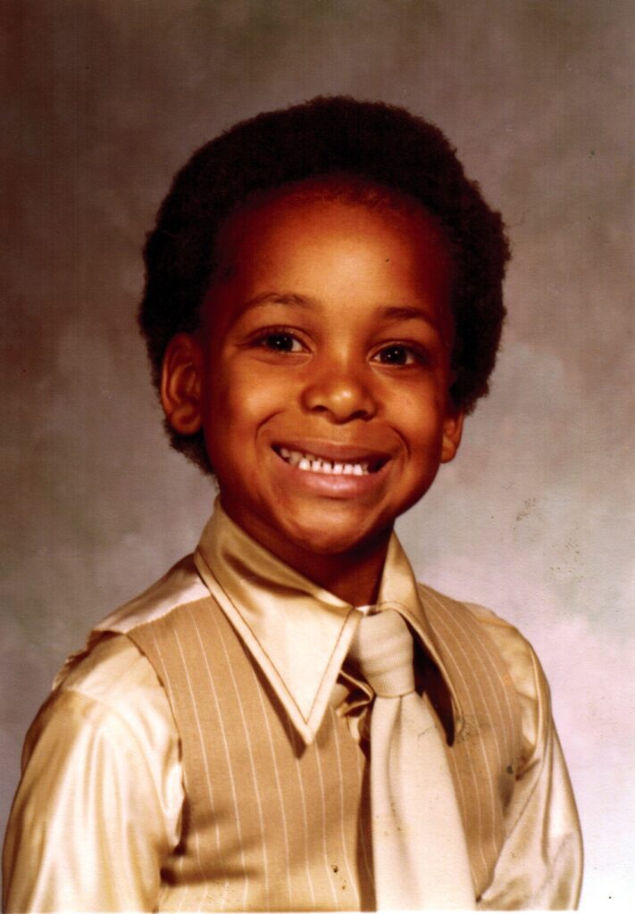 Child wearing a beige tie and vest